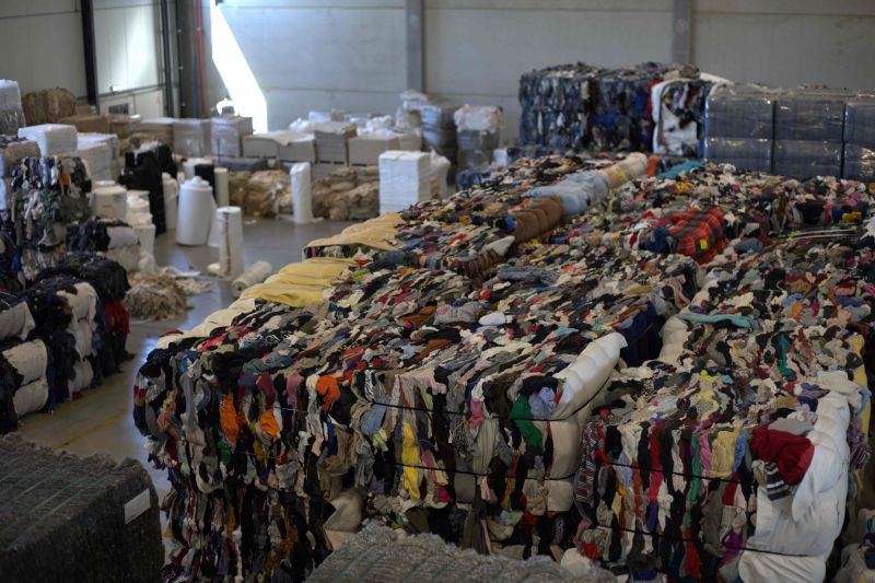Large compressed bales of discarded clothing and fabric prepared for sorting or textile processing