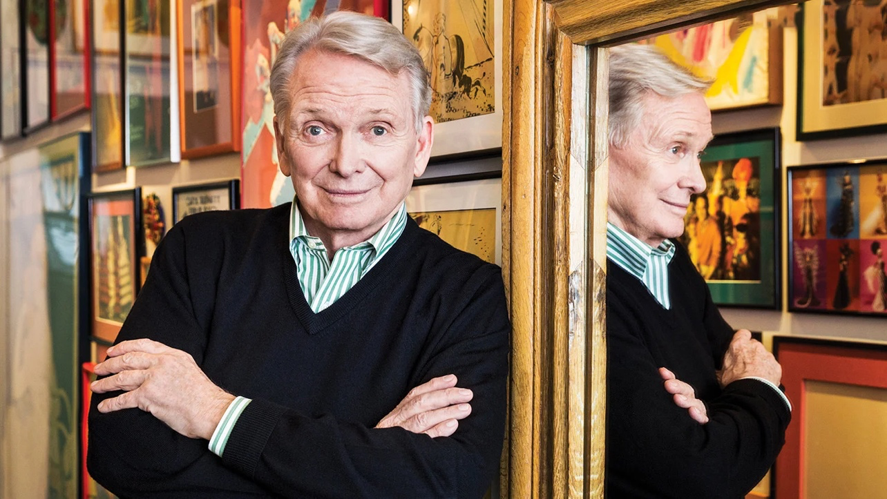 Bob Mackie standing beside a mirror.